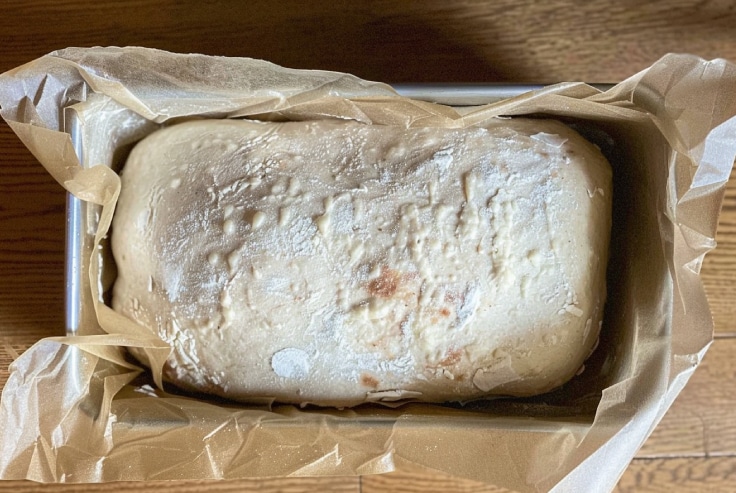 Brown-Sugar-Cinnamon-Sourdough Shaped sourdough loaf in parchment-lined pan before baking