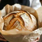 Artisan sourdough bread on a wooden board with rustic cloth