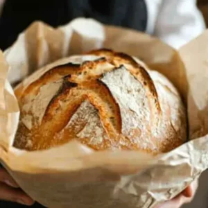 Artisan sourdough bread on a wooden board with rustic cloth