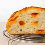 Jalapeno Cheddar Sourdough: Bold, Cheesy, and Totally Crave-Worthy 3 Close-up of a sliced jalapeno cheddar sourdough loaf on a cooling rack.